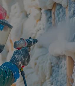 Spray gun applying closed-cell foam to seal a crawl space